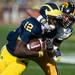 Michigan quarterback Devin Gardner, left, carries the ball while being tackled by Iowa defensive back Collin Sleeper, right, during a football game at Michigan Stadium on Saturday afternoon. Michigan defeated Iowa 42 to 17. Michigan defeated Iowa 42 to 17.Joseph Tobianski | AnnArbor.com